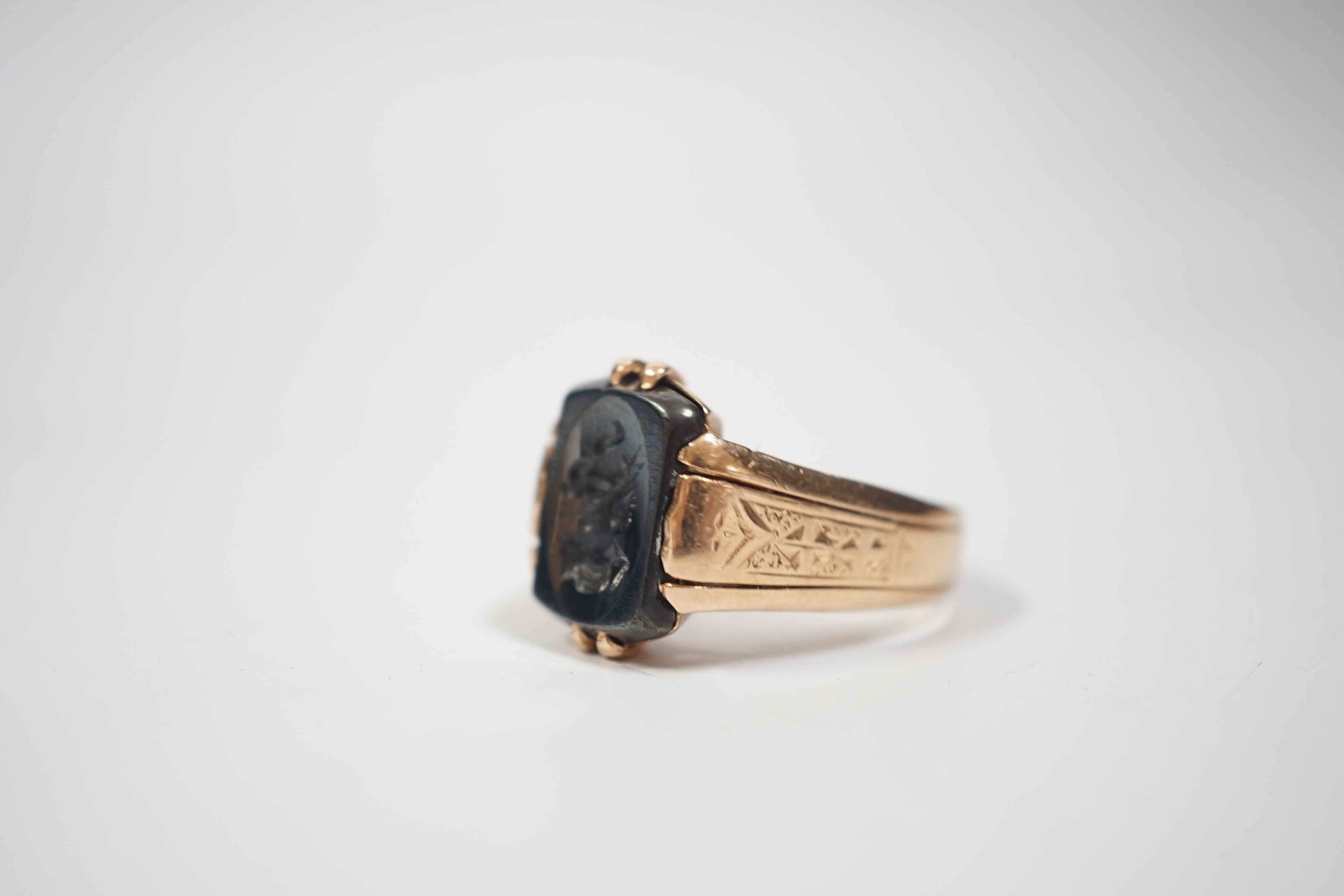 A 585 yellow metal and intaglio hematite set ring, carved with the bust of a gentleman to sinister, size S/T, gross weight 5.6 grams.